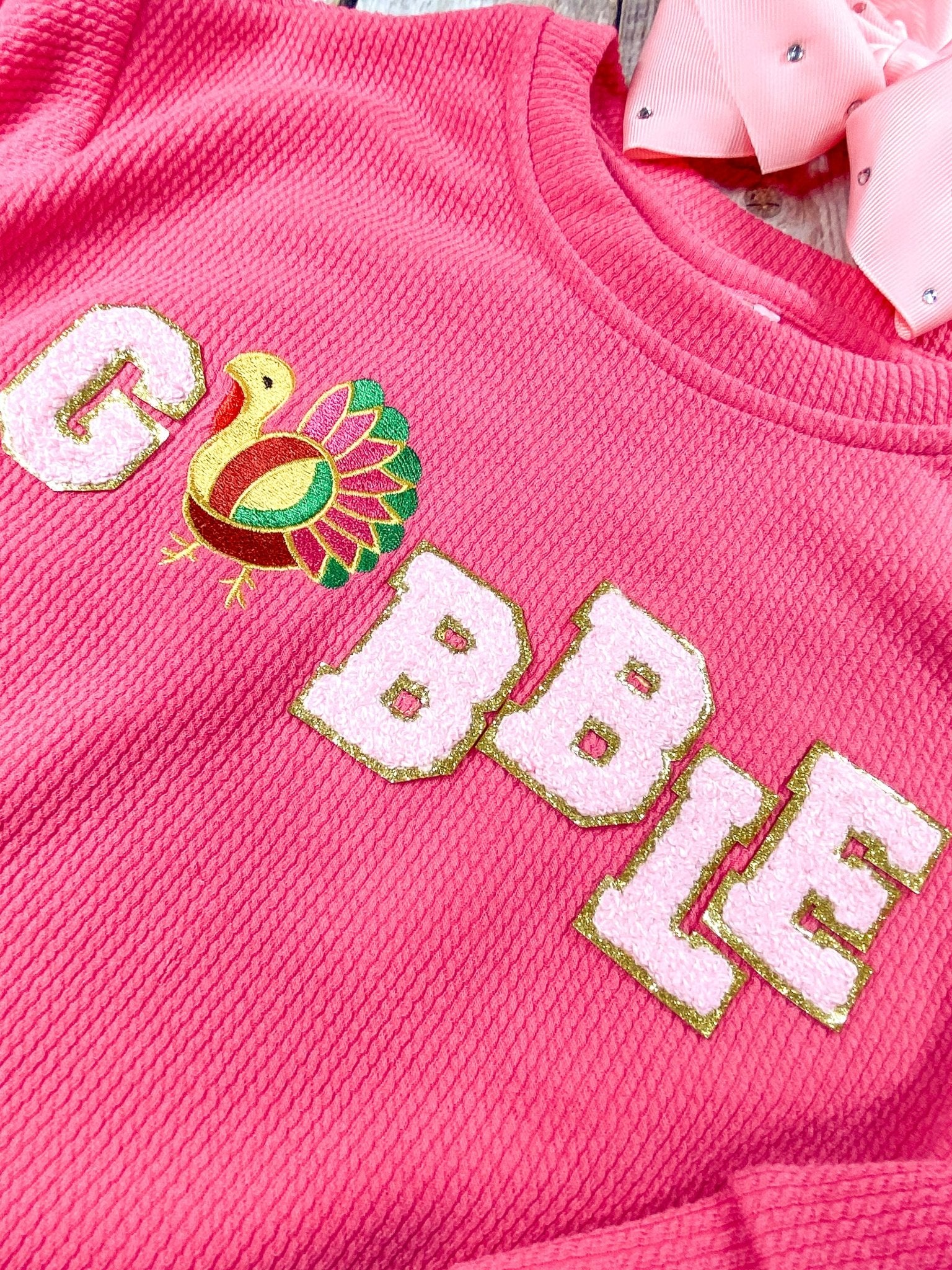 close up of the gobble chenille on front of shirt showing a colorful turkey as the "o"