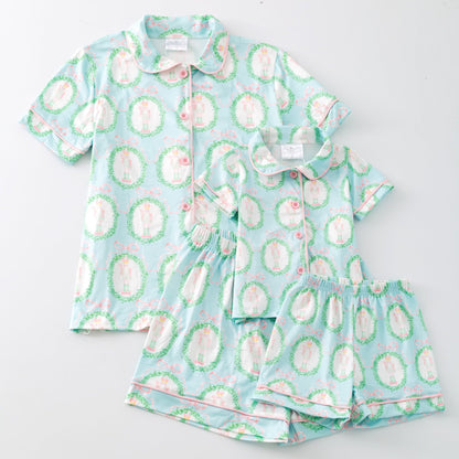 Children's pajama set with a light blue background and green and pink pattern on a white background