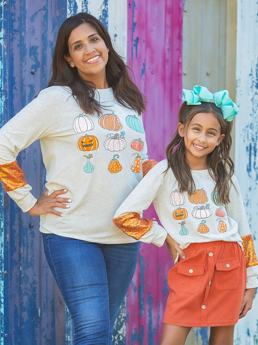 Mom and daughter in matching pumpkin print tops with sequin sleeves