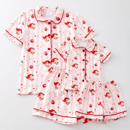 Pink pajama set with santa pattern on a light gray background