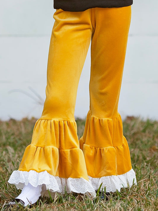 Girl wearing mustard velvet leggings with lace trim on the grass