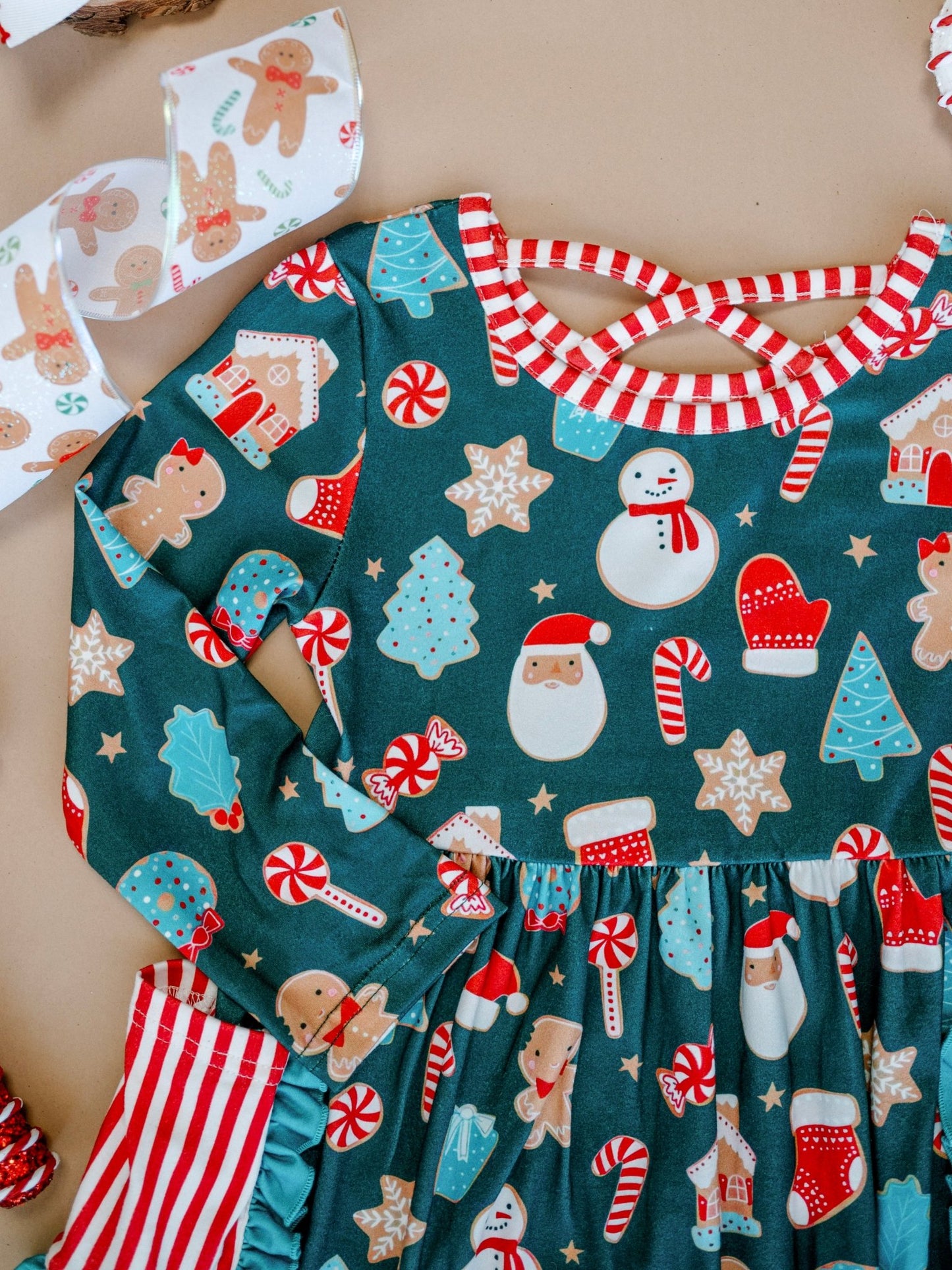 Children's Christmas-themed outfit with patterned dress and apron on a neutral background