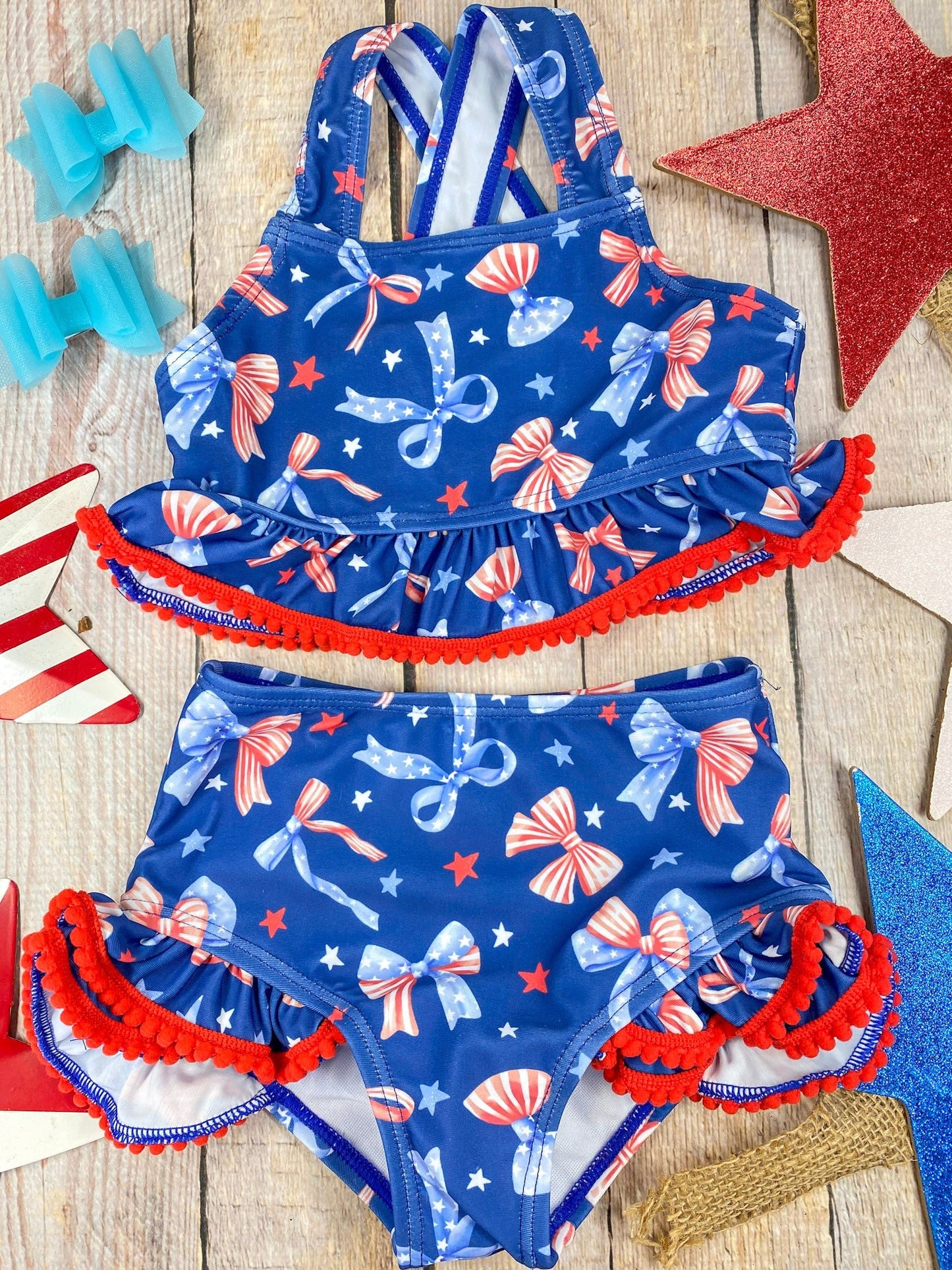  Patriotic Bow Print Ruffle Swim Set on a wooden background