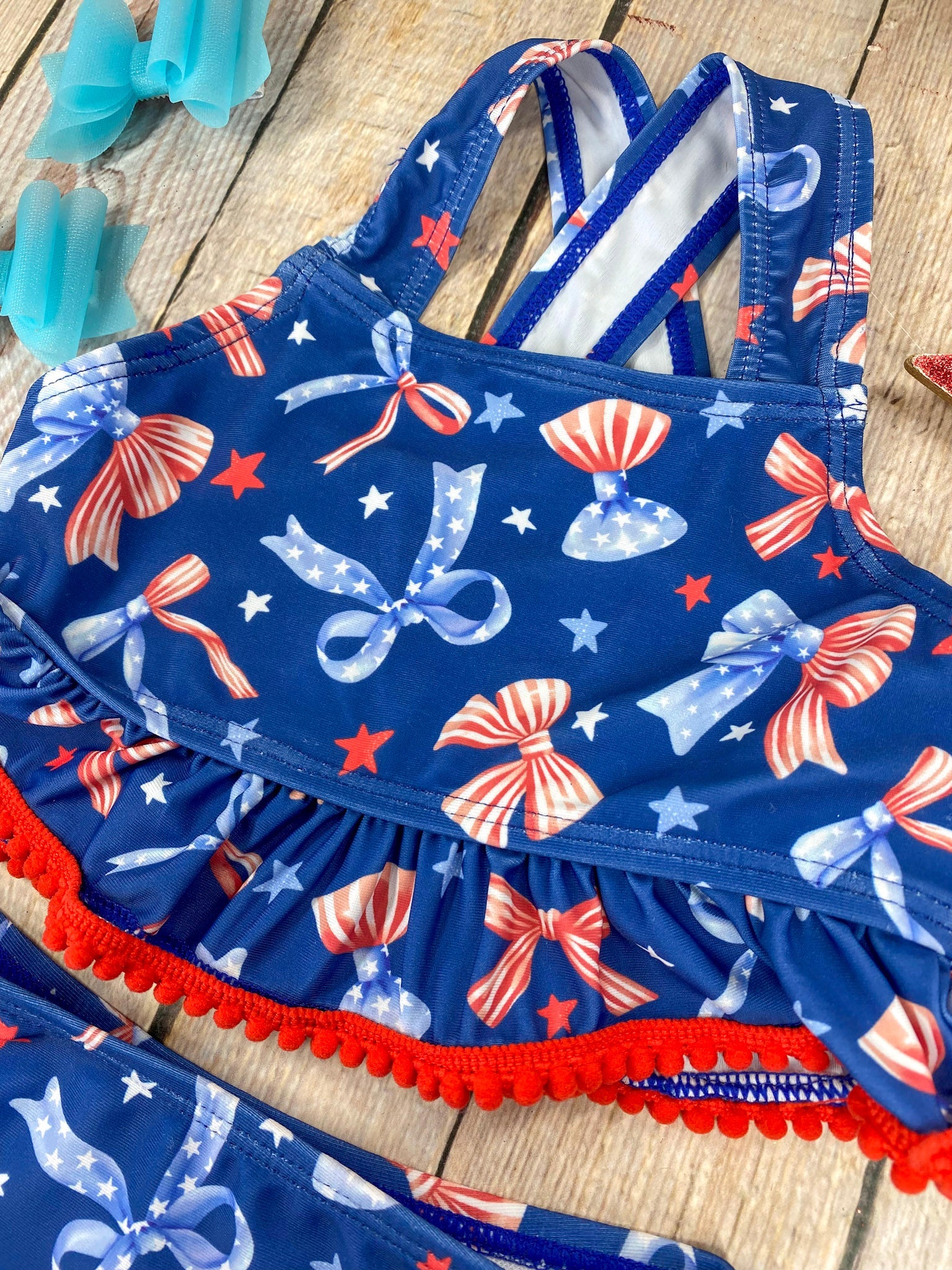  Patriotic Bow Print Ruffle Swim Set on a wooden background