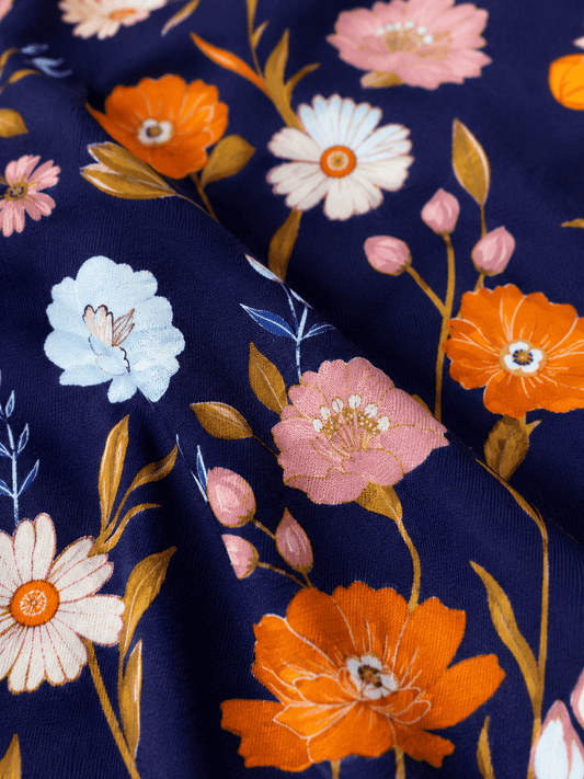 Close-up of navy floral girls boutique dress fabric showing blue, orange and blush pink floral print details. - Alternative view