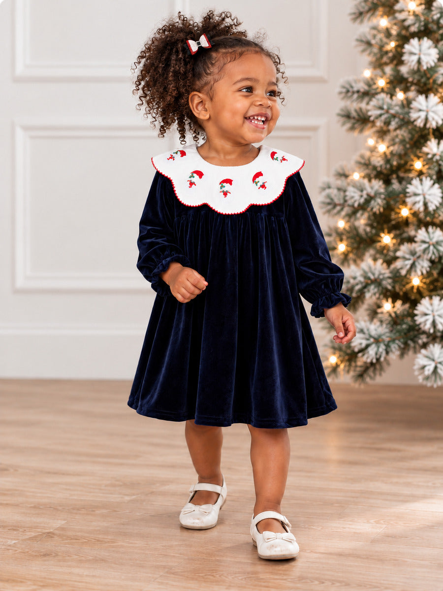 Navy Velvet Santa Collar Girls Dress on model by Christmas tree