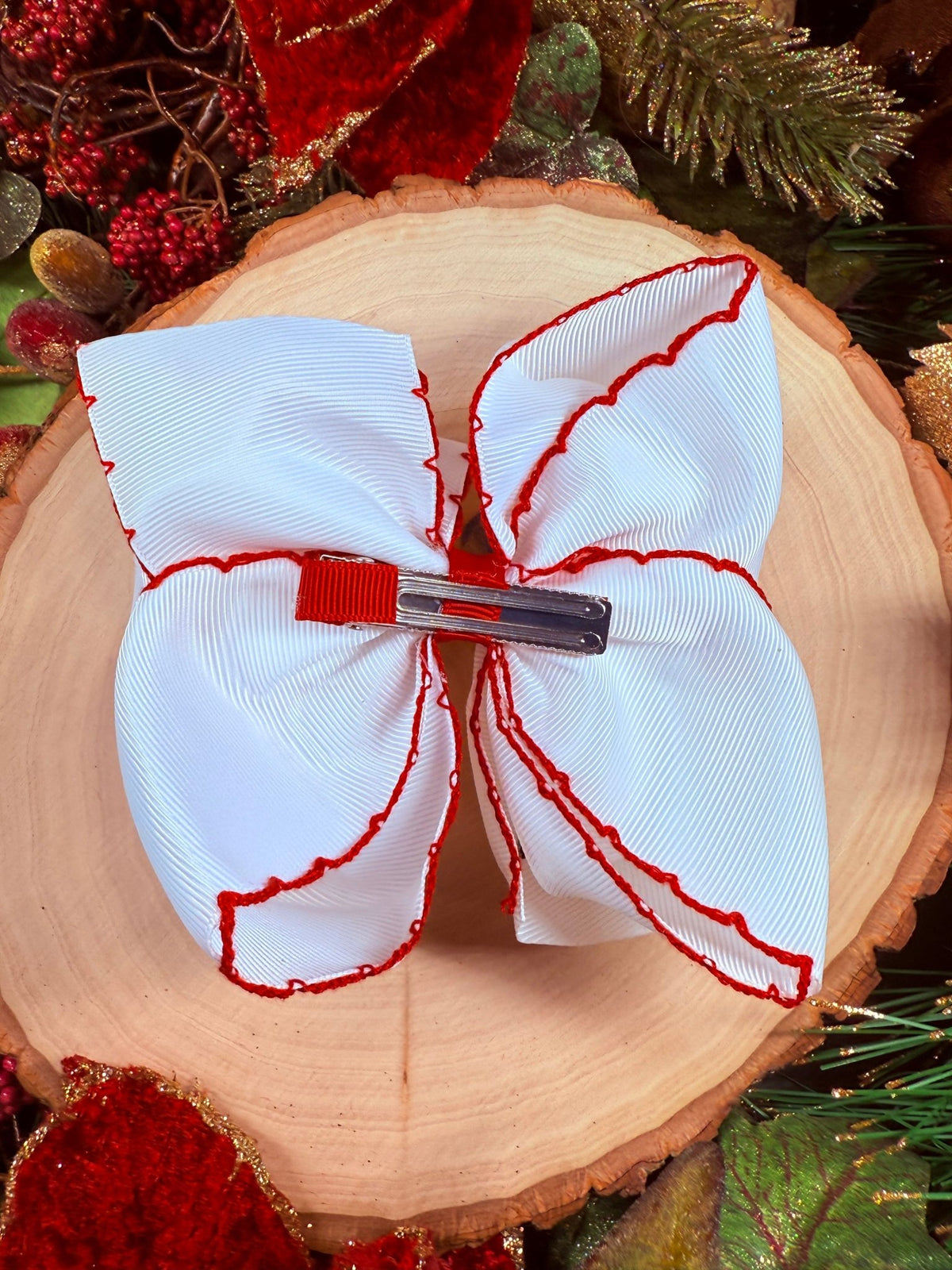Back of nutcracker embroidered moonstitch hair bow showing alligator clip