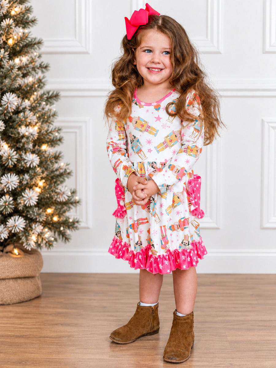 Girl wearing a nutcracker galore Christmas twirl dress with a big hair bow