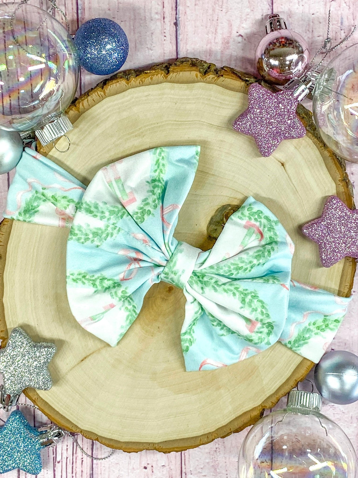 Nutcracker print bow headbands on a wooden surface with Christmas ornaments