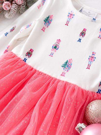 Close-up of the Pink Nutcracker Christmas tutu dress featuring pastel nutcracker print, glitter tulle skirt, and soft holiday fabric details for girls.