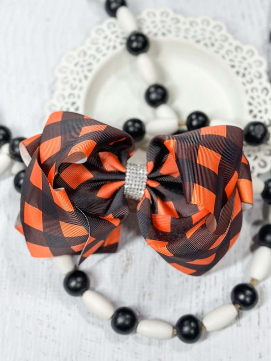 Orange and black buffalo plaid Texas size hair bow with rhinestone center