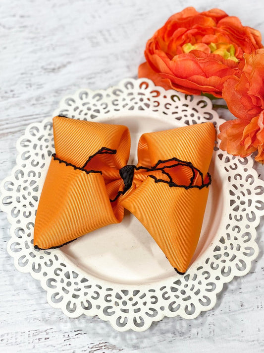 Our orange and black moonstitch hair bows are made with 2.25" ribbon and measure approximately 4-5 inches in width with contrast stitch edging. 