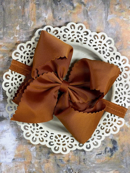 light brown hair bow headband on a decorative white plate with a textured background