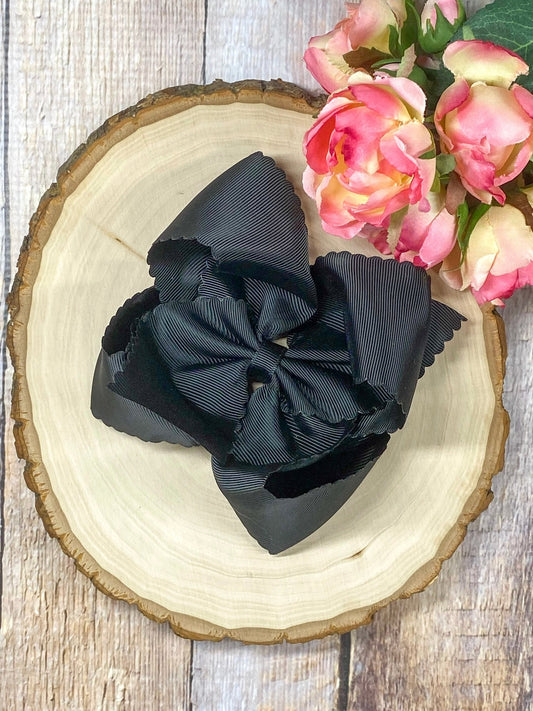 black hair bow on wooden display