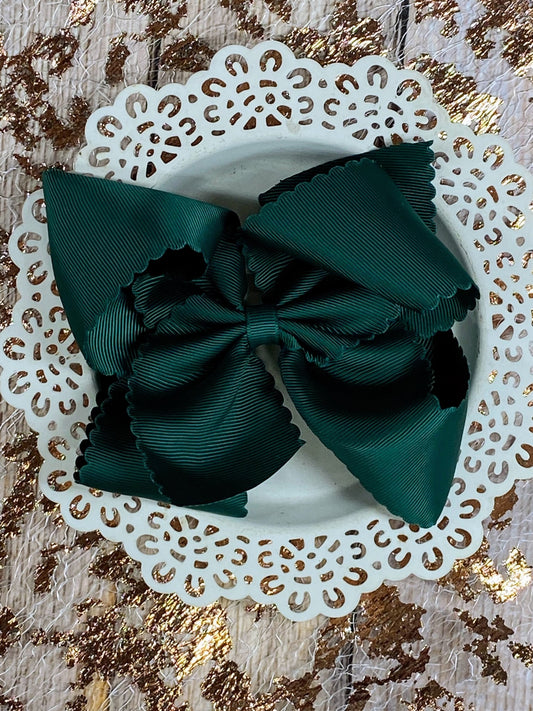 Green bow on a white lace holder against a gold and brown textured background