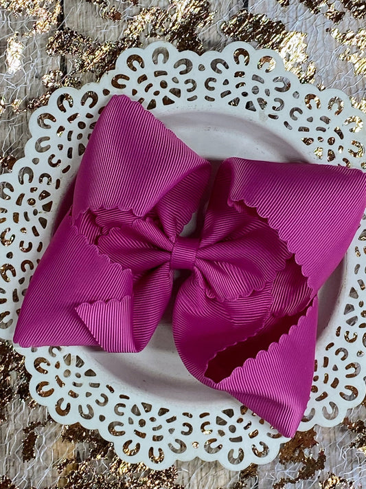Pink bow on a white doily with a gold leaf background