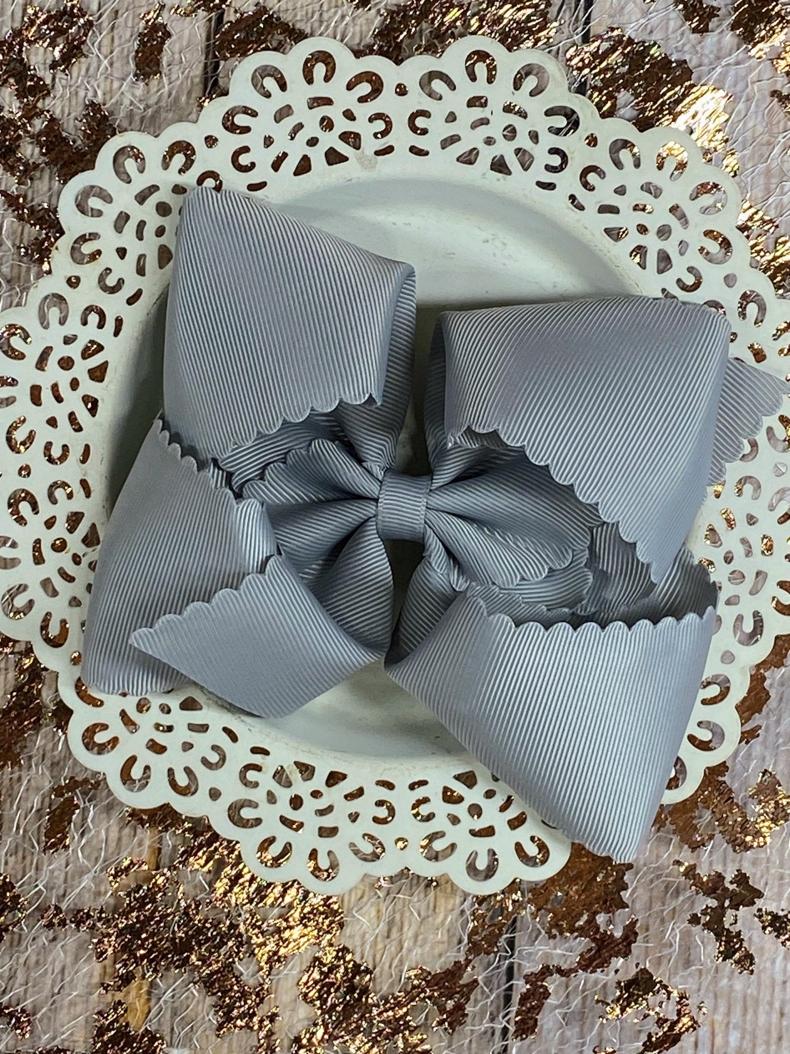 Gray bow on a decorative white plate with a gold glittery background