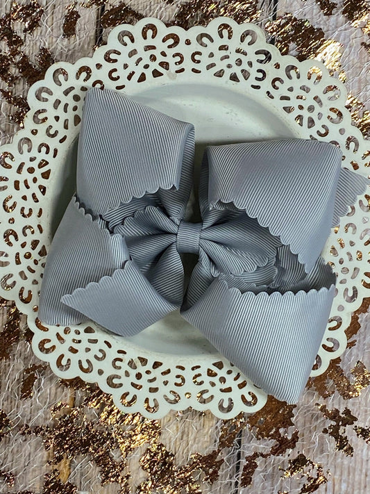Gray bow on a decorative white plate with a gold glittery background