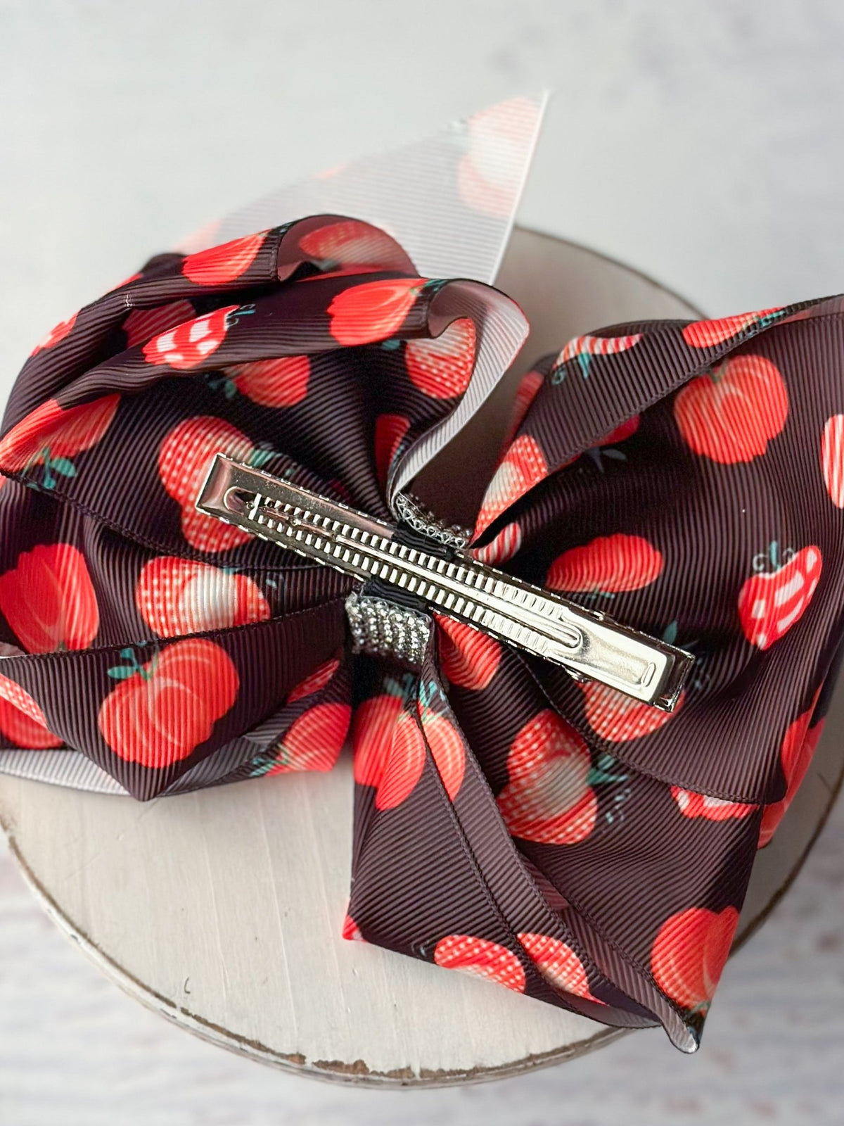 Back of patterned pumpkins hair bow showing single prong alligator clip