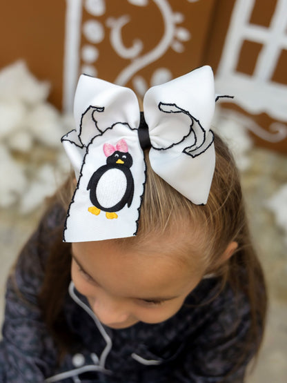 Girl wearing a penguin embroidered black moonstitch hair bow on alligator clip