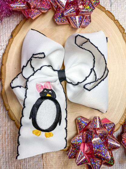 Penguin embroidered hair bow with black moonstitch trim, flat lay