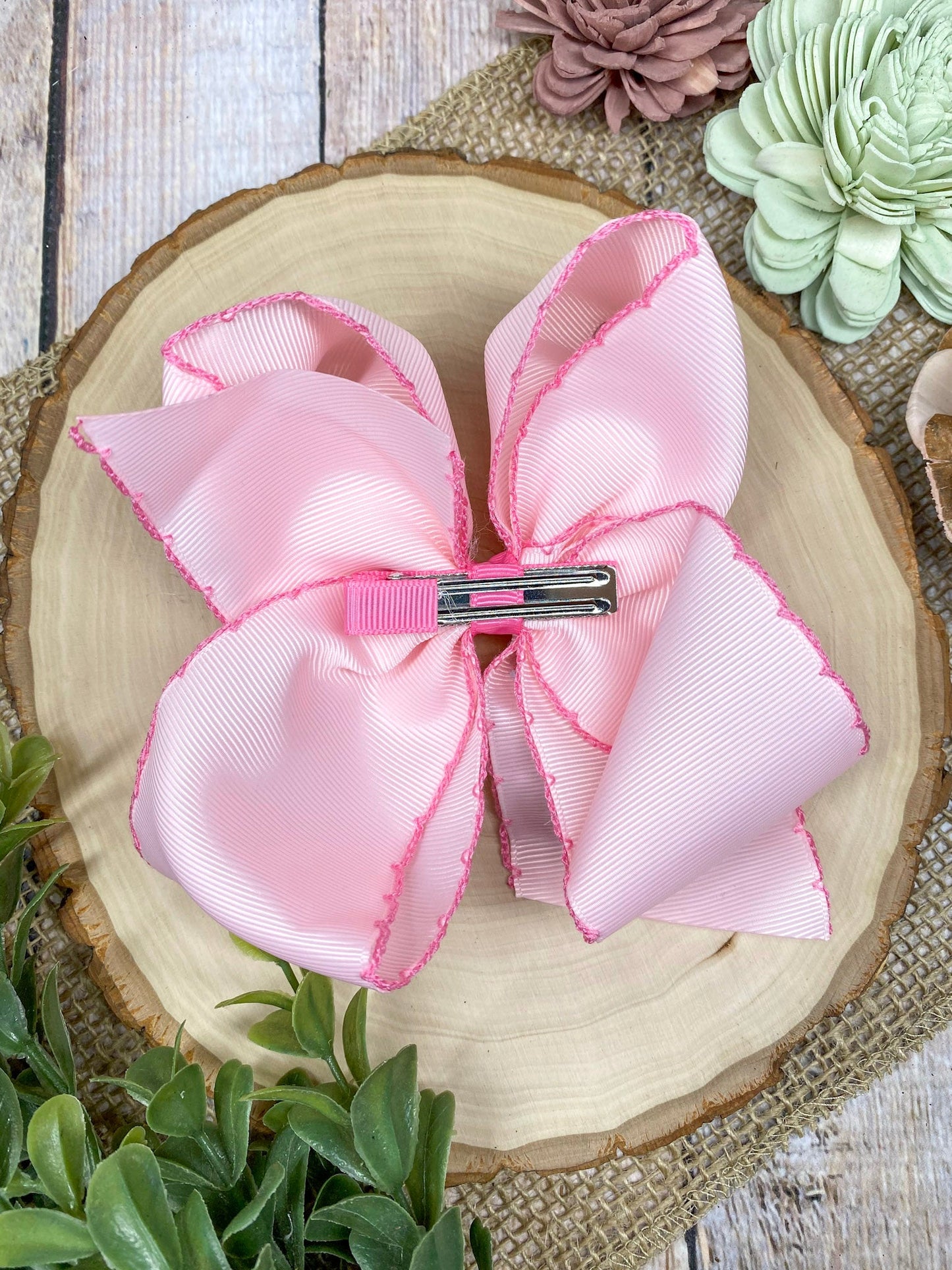 Pink Pickle Jar Moonstitch Hair Bow on a wooden background