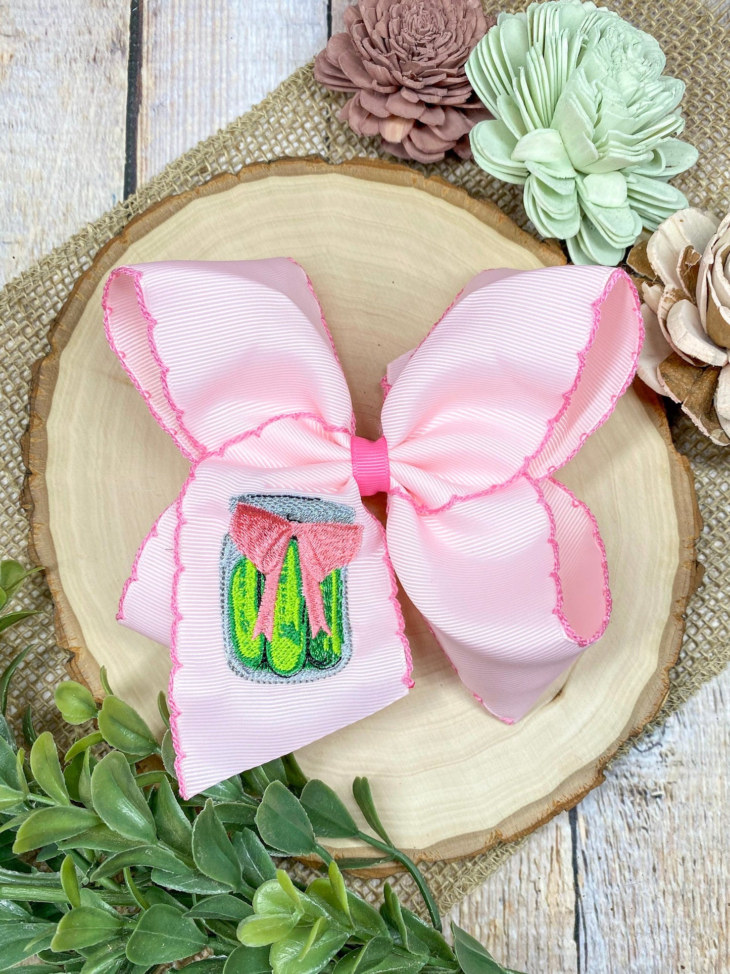 Pink Pickle Jar Moonstitch Hair Bow on a wooden background