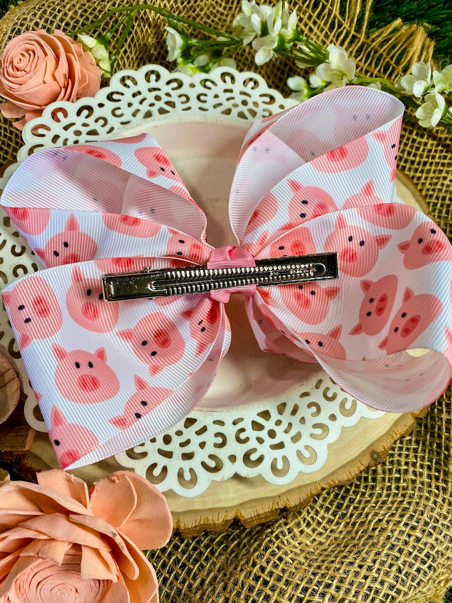 Large pink bow with pig pattern on a decorative surface with flowers