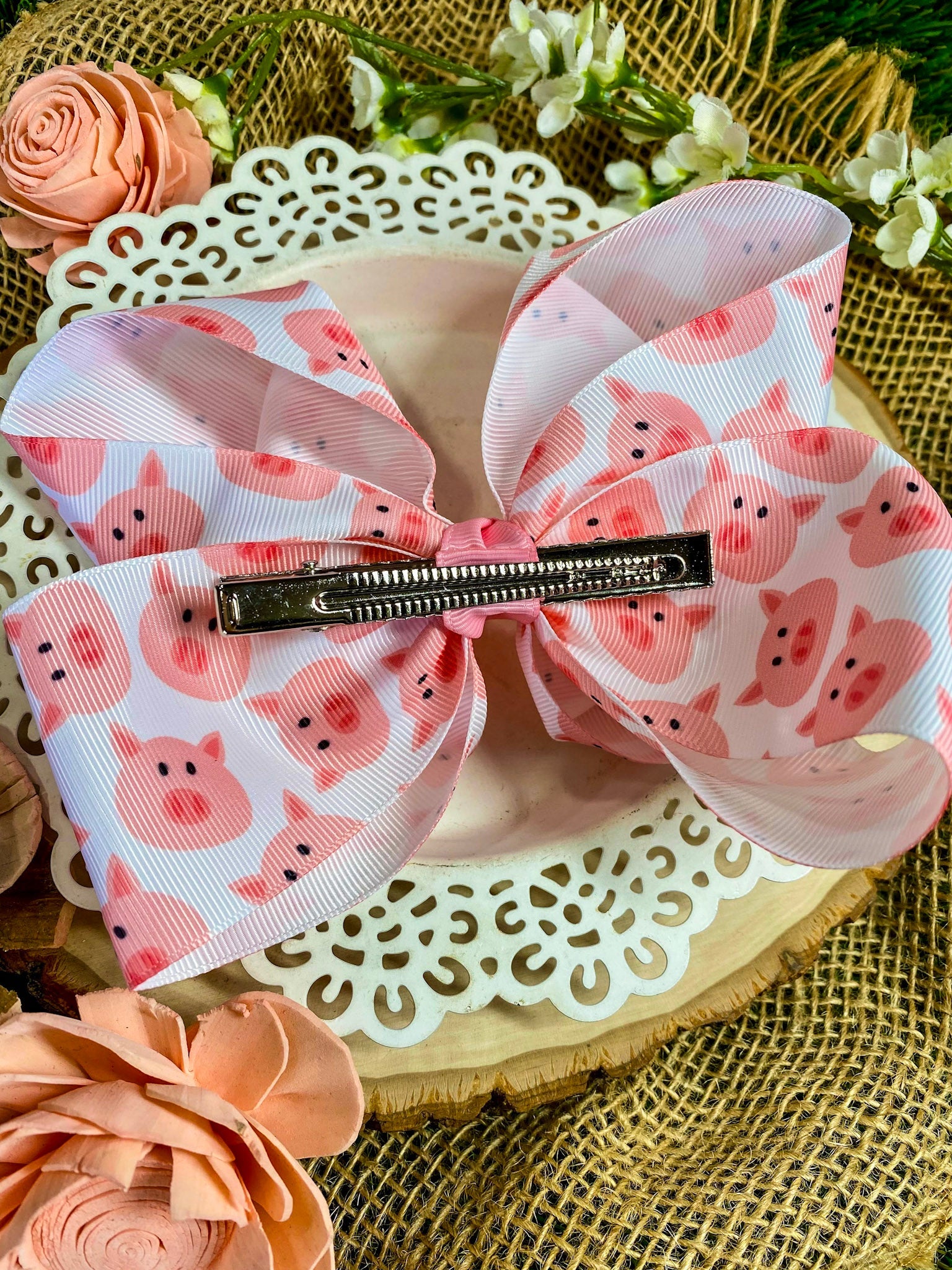 Large pink bow with pig pattern on a decorative surface with flowers