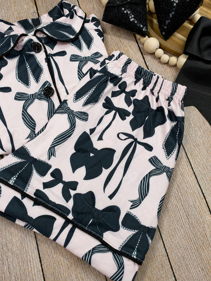 mom and me pajamas in pink with black bow pattern on a light background