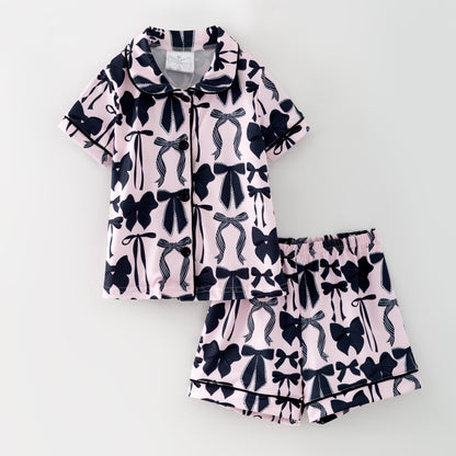 Pajama set with black bow pattern on a light pink background