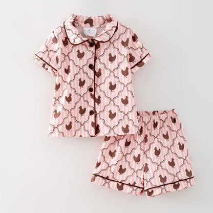 Pink pajama set with chicken pattern on a light gray background