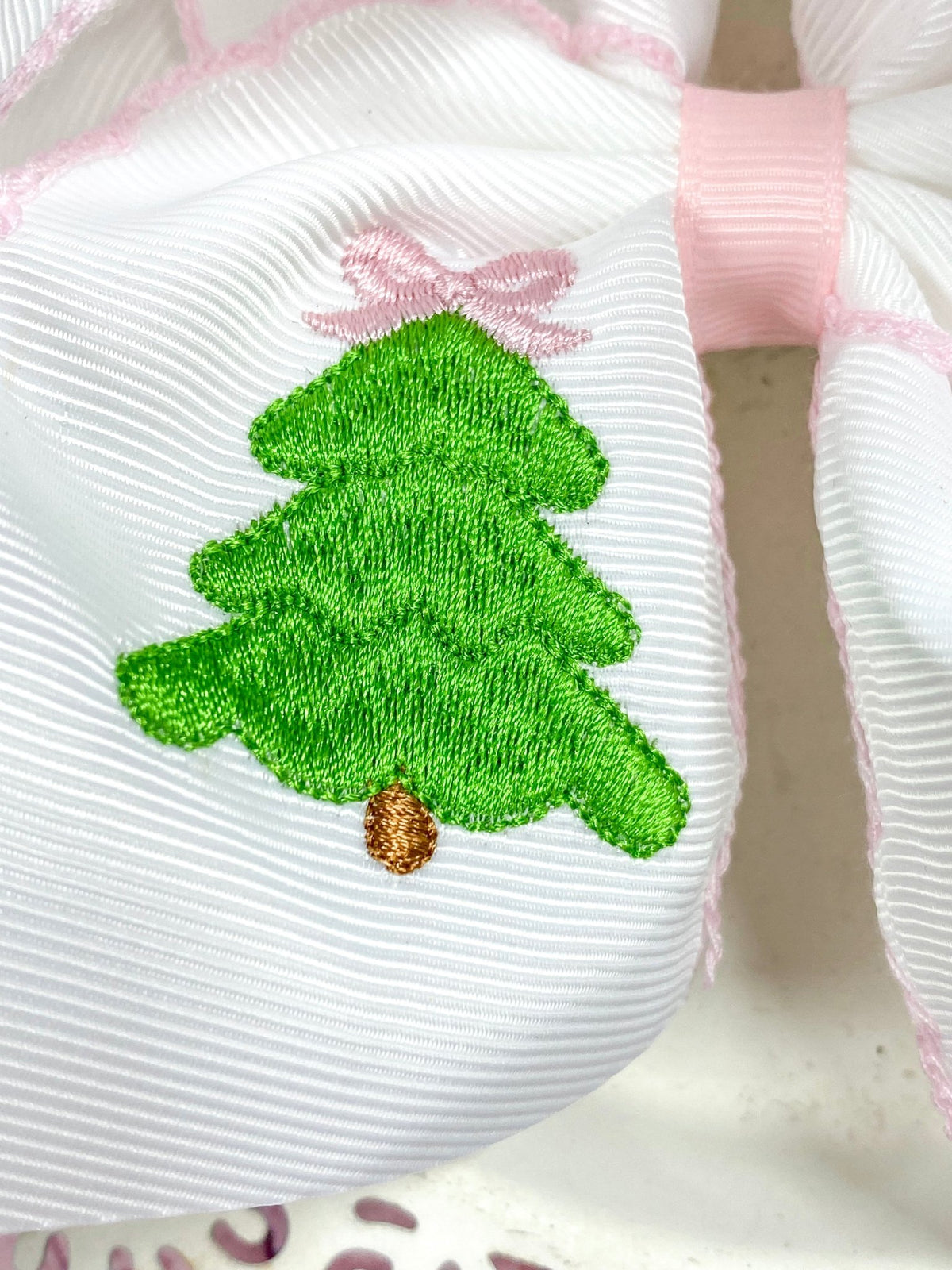 Close-up of green Christmas tree embroidery detail on hair bow