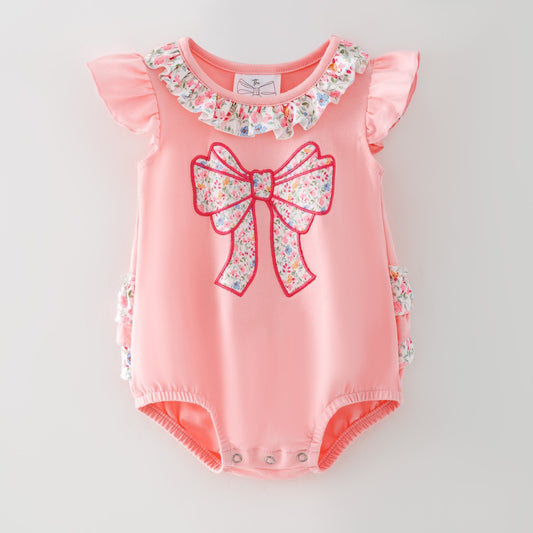 Pink baby romper with floral bow and ruffles on a light gray background - Alternative view
