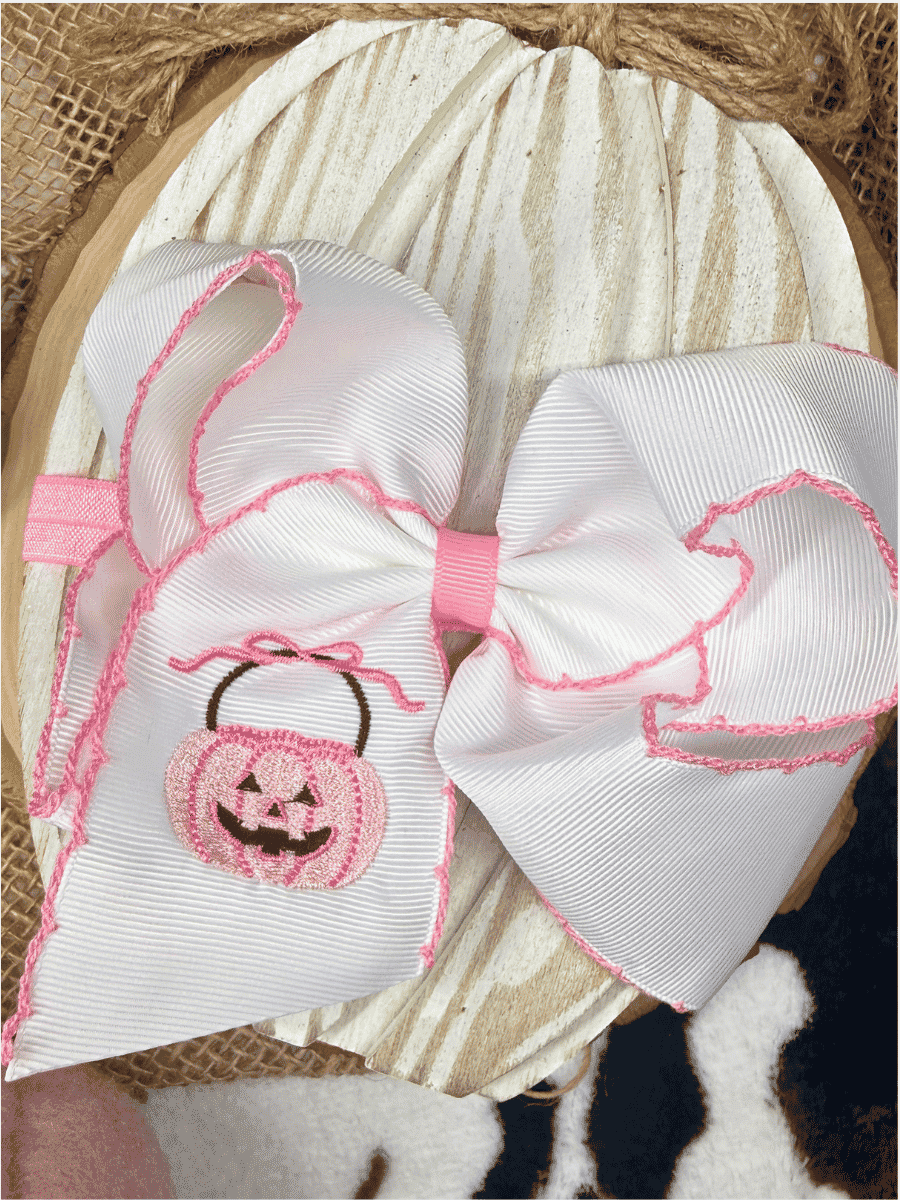 Pink jack-o'-lantern Halloween bow on soft nylon headband