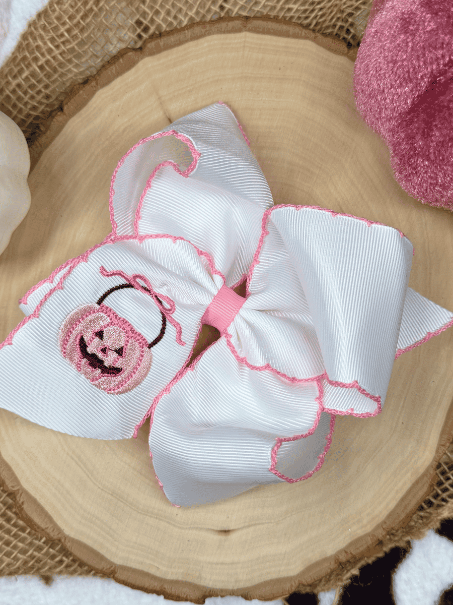 Pink jack-o'-lantern Halloween hair bow with pink moonstitch edge