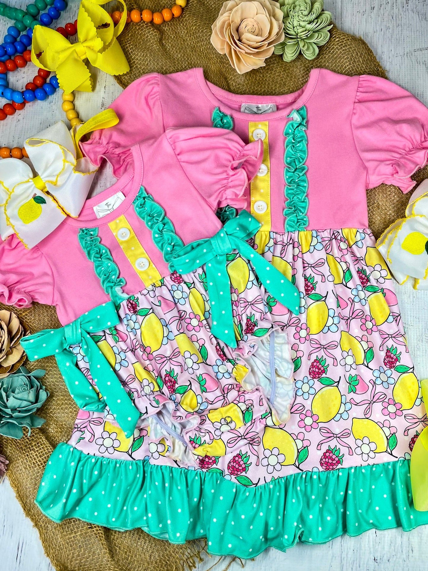 lemon and bows children's matching dress and romper on a white marble background