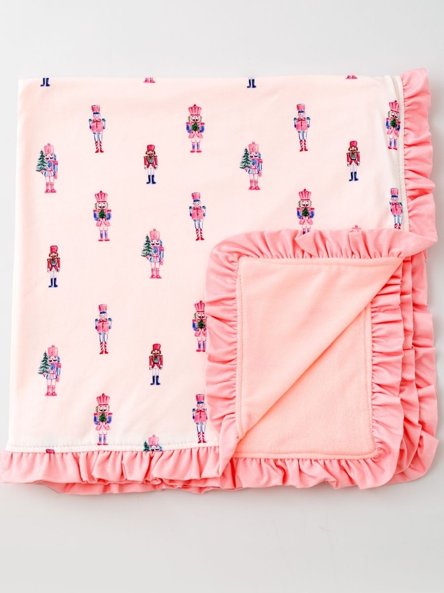 Pink Nutcracker Christmas ruffle minky baby blanket featuring a pastel nutcracker print and ultra-soft blush plush backing.