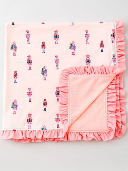 Pink Nutcracker Christmas ruffle minky baby blanket featuring a pastel nutcracker print and ultra-soft blush plush backing.