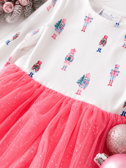 Close-up of the Pink Nutcracker Christmas tutu dress featuring pastel nutcracker print, glitter tulle skirt, and soft holiday fabric details for girls.