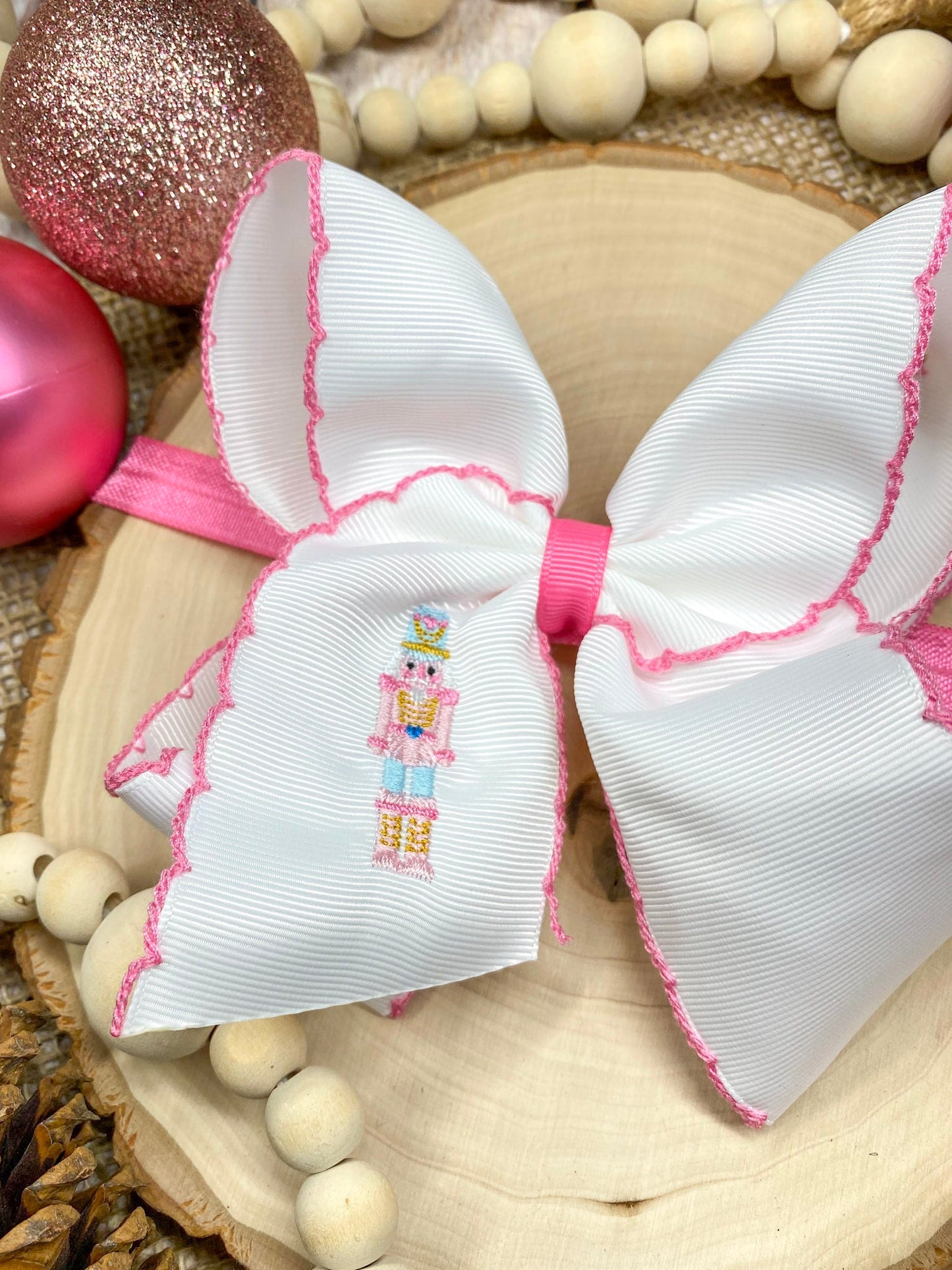 Pink Nutcracker Embroidered Moonstitch Headband on a wooden background