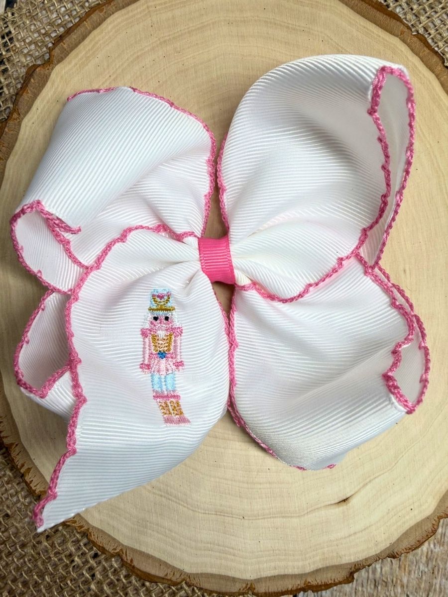Pink Nutcracker Embroidered Moonstitch Hair Bow on a wooden background