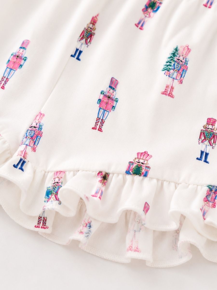 Close-up of Pink Nutcracker Christmas Mommy & Me pajamas with pastel nutcracker print, soft fabric, and ruffle shorts.