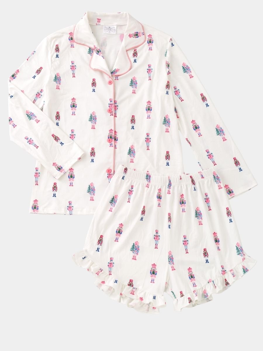 Women's Pink Nutcracker Christmas pajama set with pastel nutcracker print, button-front top, and ruffle shorts.