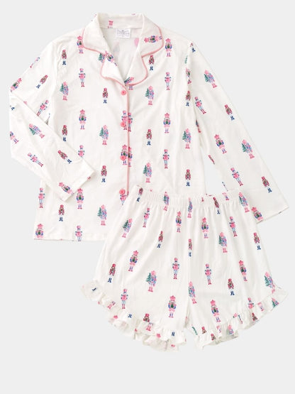 Women's Pink Nutcracker Christmas pajama set with pastel nutcracker print, button-front top, and ruffle shorts.