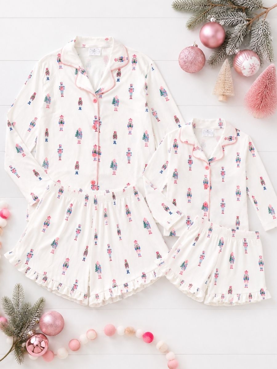 Pink Nutcracker Christmas Mommy & Me matching pajamas with pastel nutcracker print in a festive holiday flatlay.