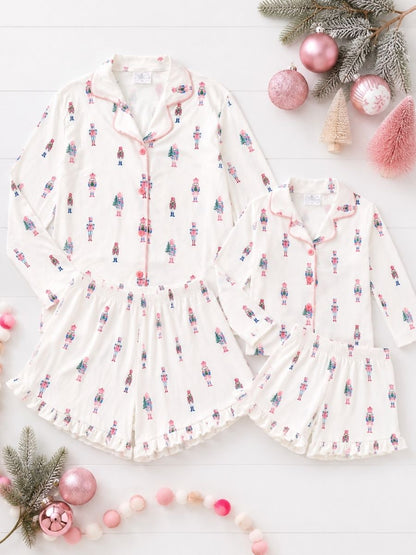 Pink Nutcracker Christmas Mommy & Me matching pajamas with pastel nutcracker print in a festive holiday flatlay.