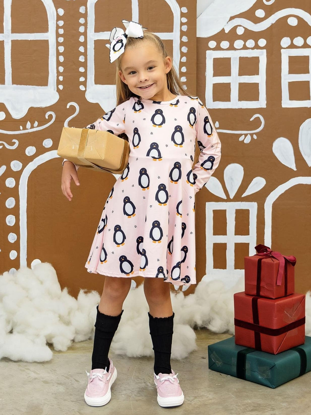 Girl wearing a pink penguin Christmas twirl dress
