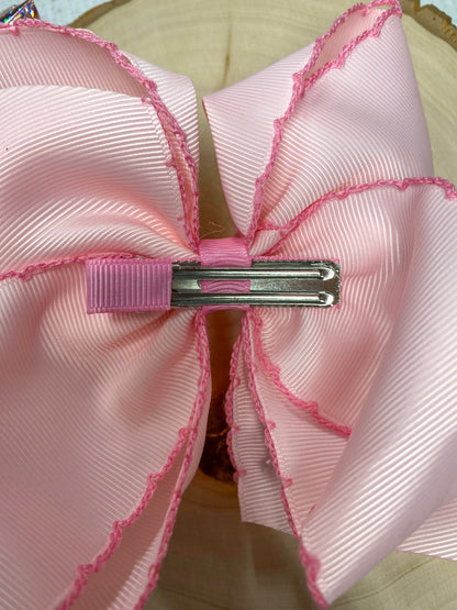 Back of pink Santa hair bow showing lined alligator clip
