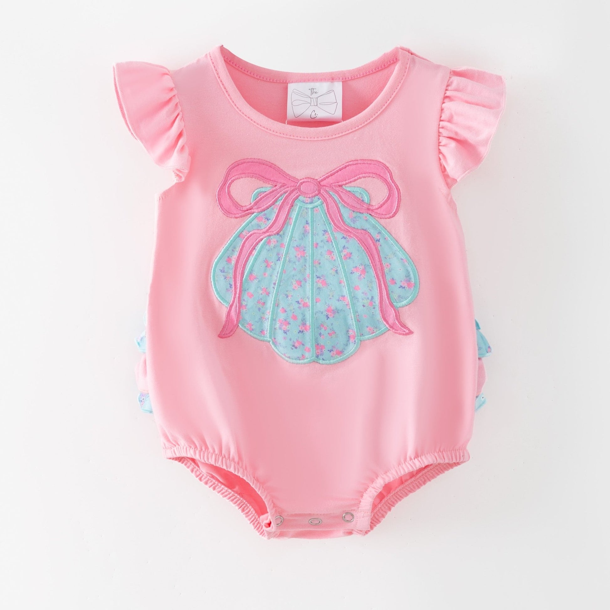 Pink baby romper with a blue bow design on a white background